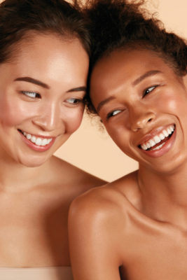Two women leaning heads together