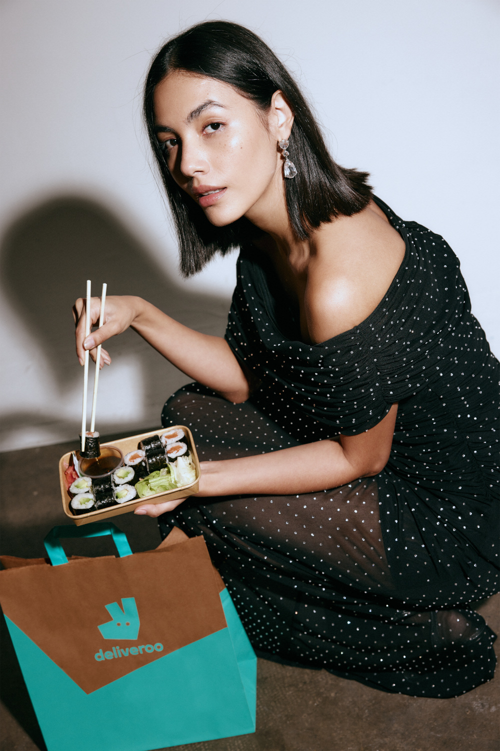 Woman crouched down next to takeaway bag