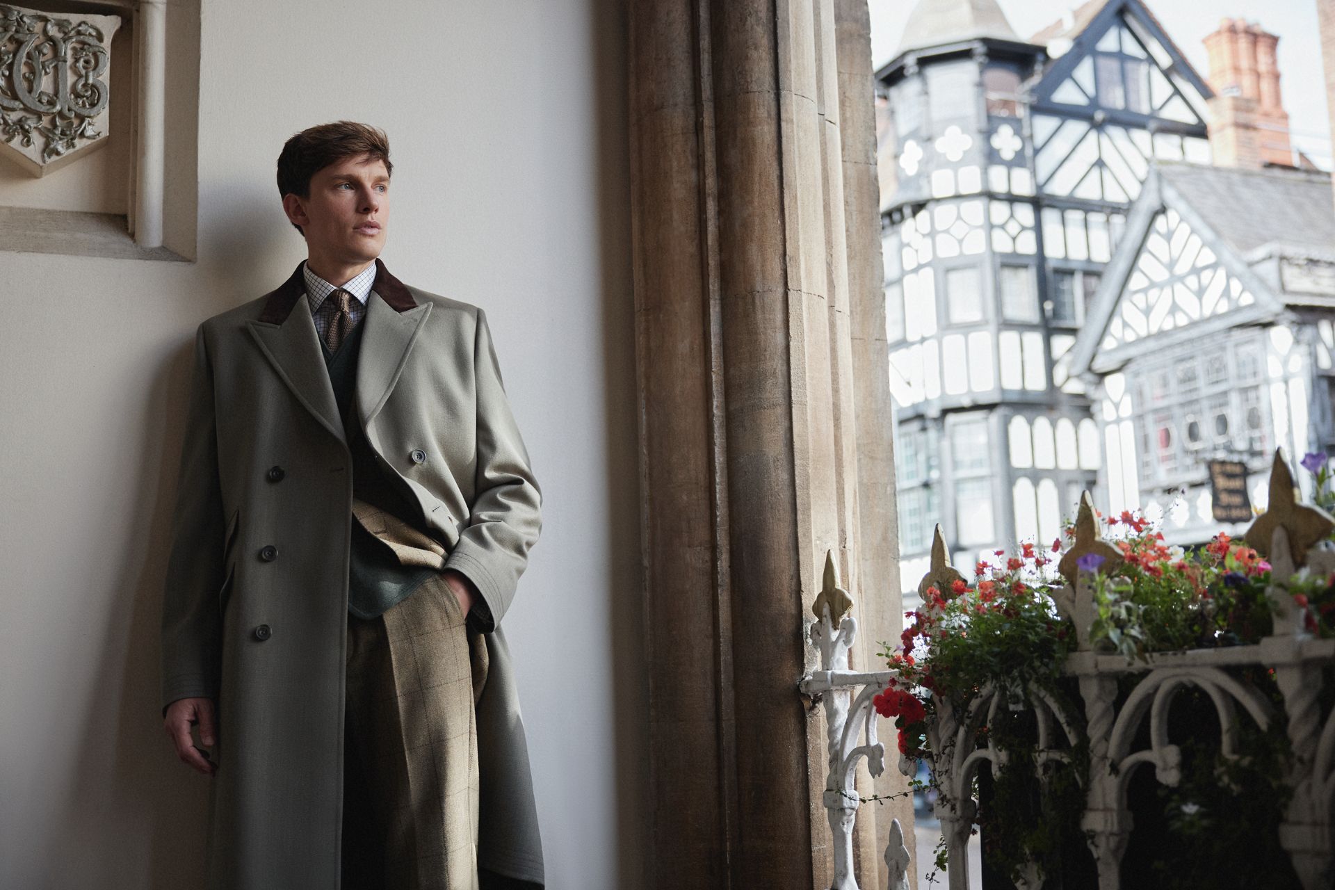 Man leans against wall in Oliver Brown overcoat
