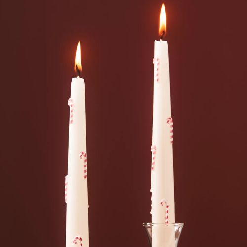 White tapered candles with a candy cane motif