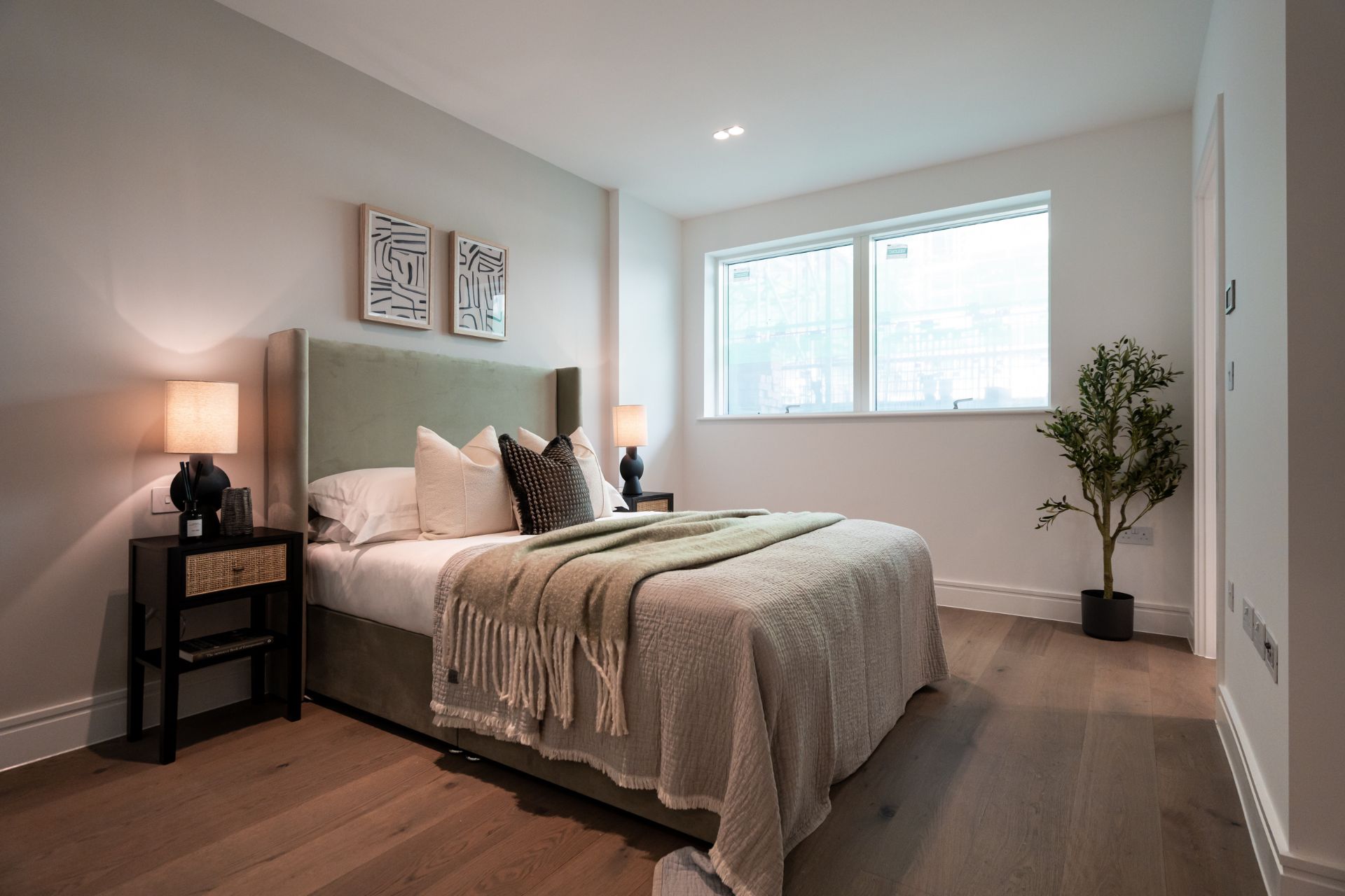 Bedroom with large window and pale wooden floors