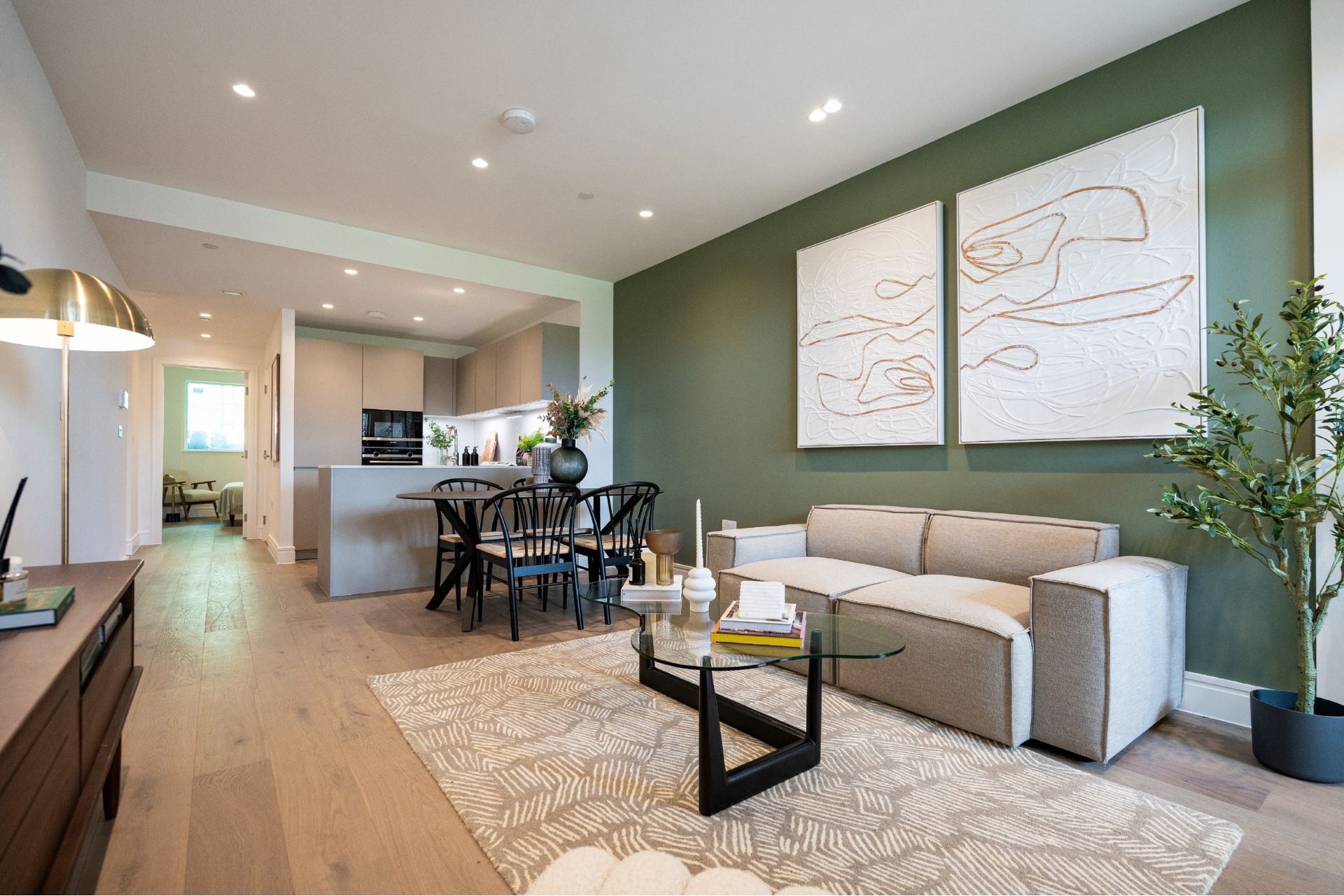 Living room with cream sofa and sage green feature wall
