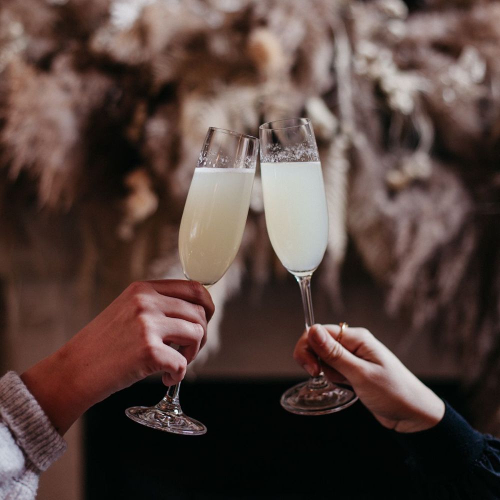 Clinking glasses in front of a festive display