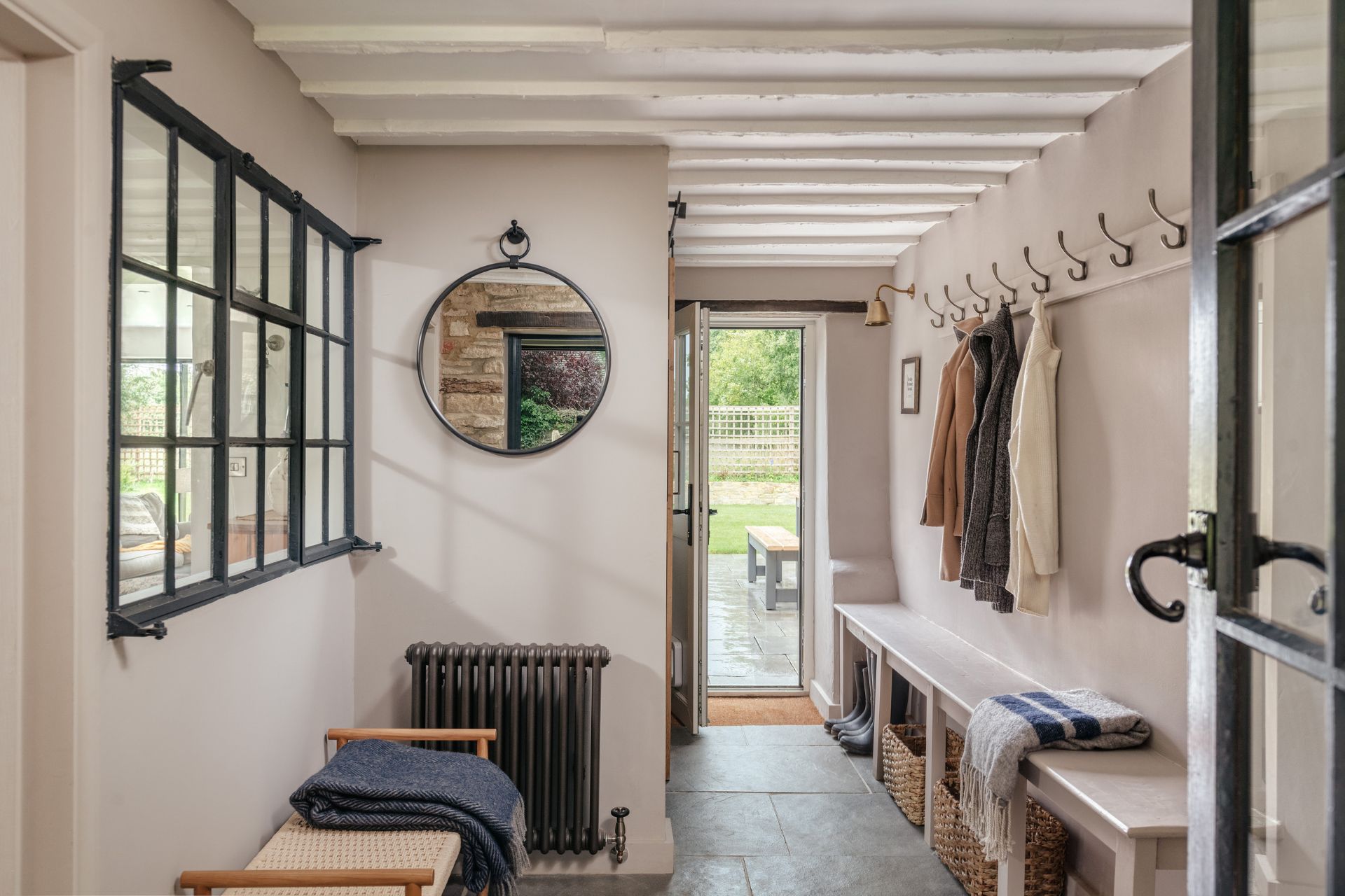 Cottage boot room with white walls and exposed beams