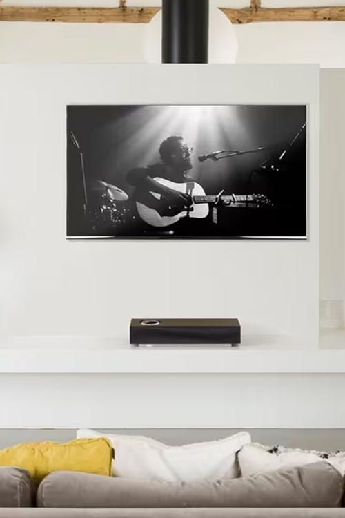 A TV with a speaker on a wall