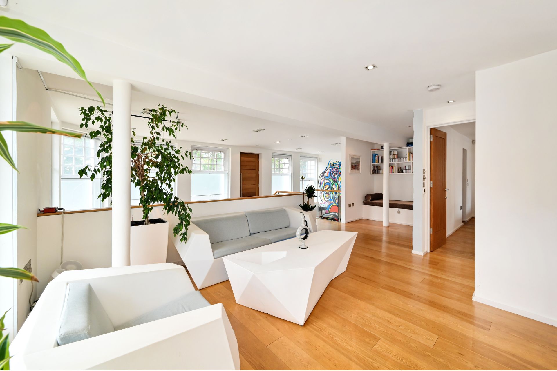 Living room with wooden floors and white sofas