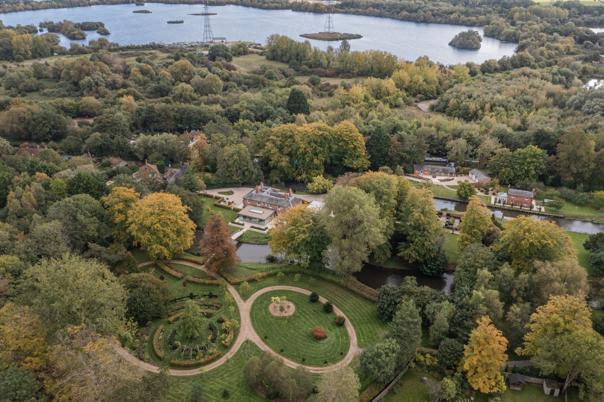 Aerial view of Georgian mill with waterways, landscaped gardens and outbuildings.