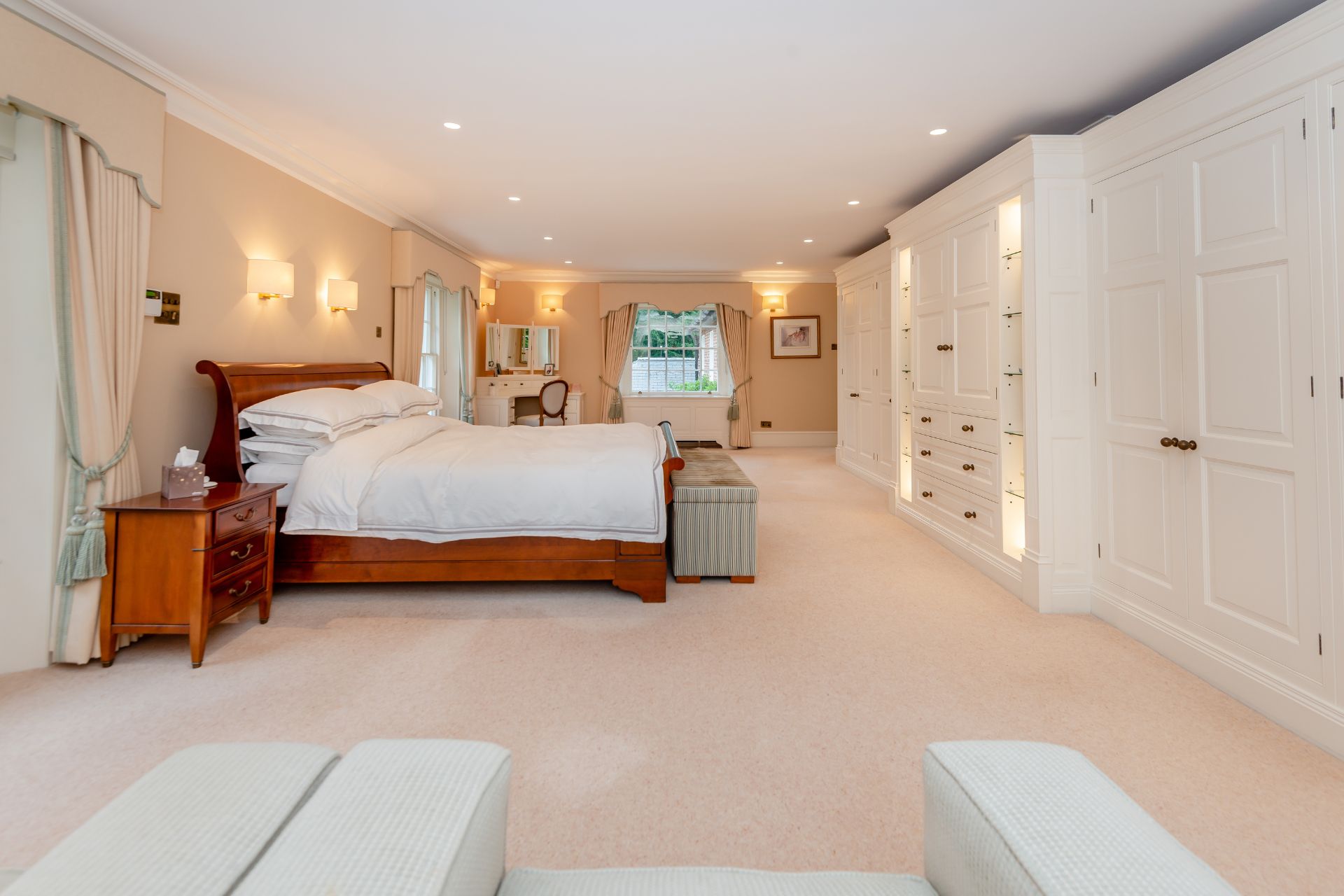 Large bedroom with white fitted wardrobes.