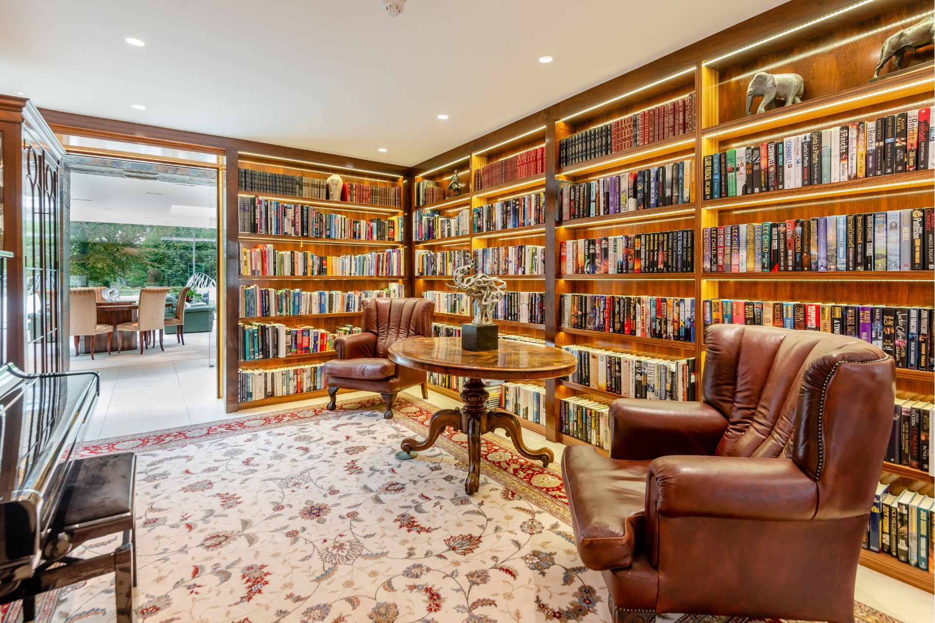Home library with a leather armchair and floor-to-ceiling windows.