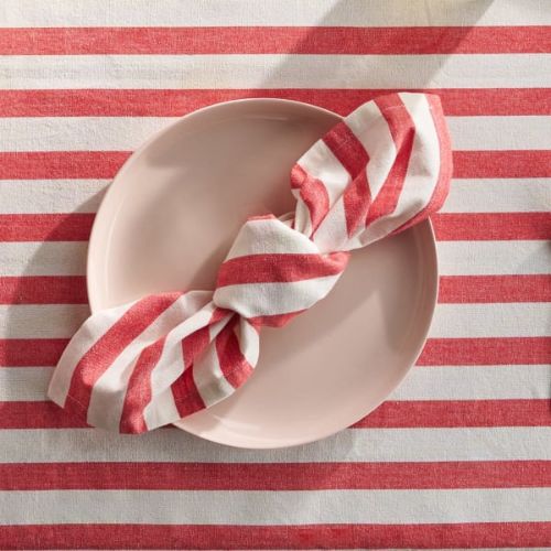 Red and white striped tablecloth with white plate and matching striped napkin