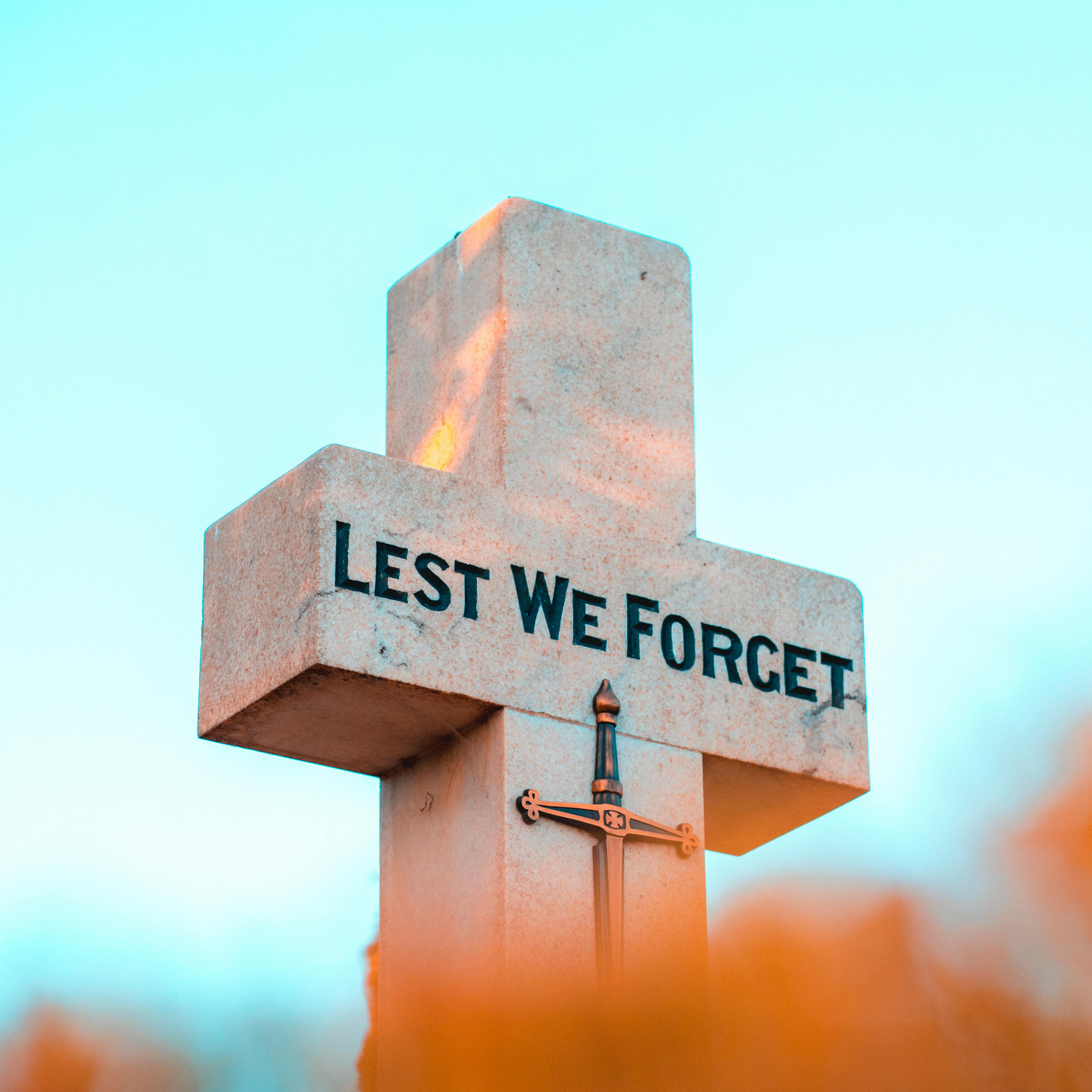 A cross with the words 'lest we forget'