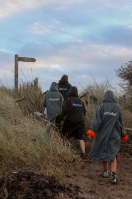 Swimmers wearing dryrobes in the dunes