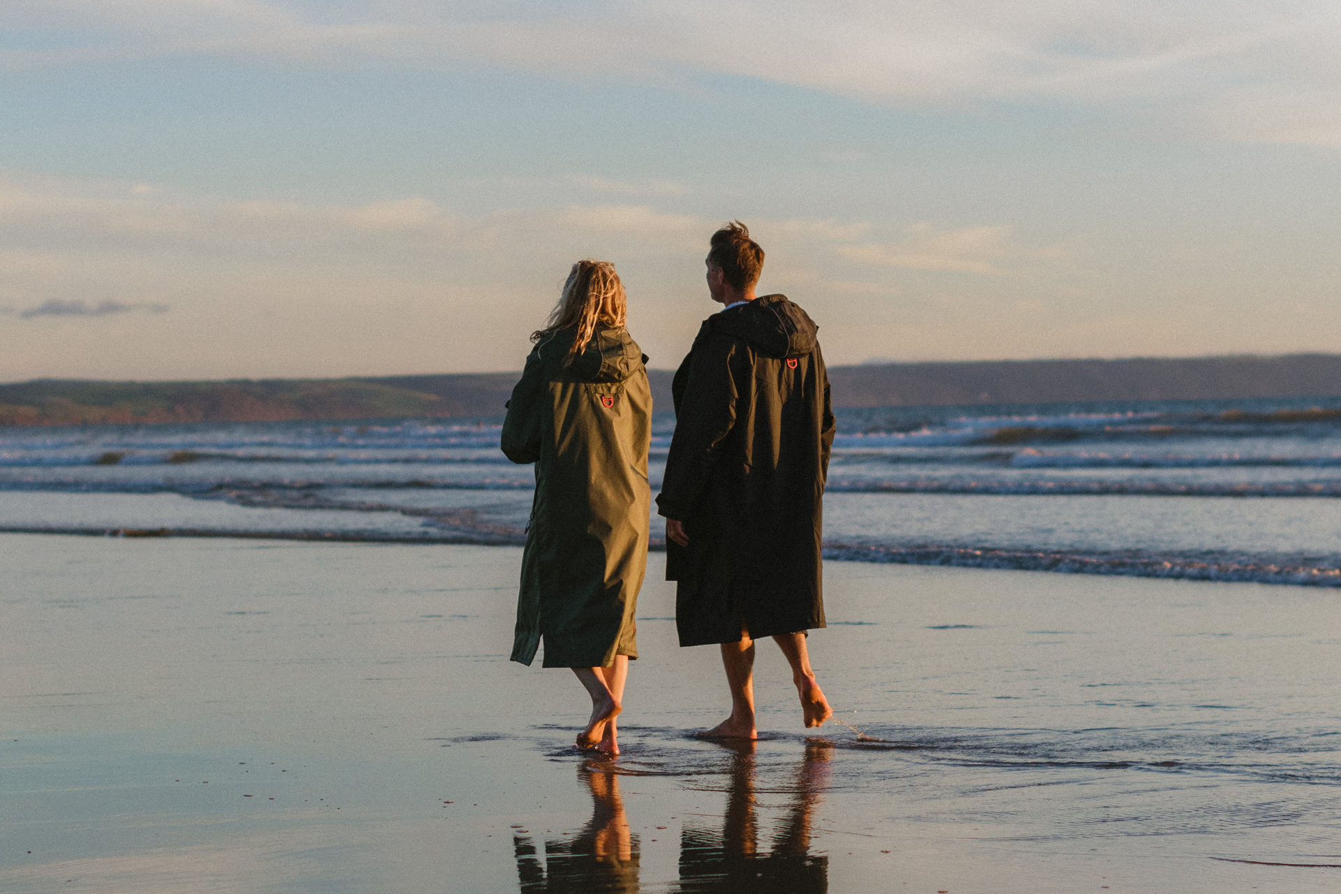 Two people walking on the beach in Devon