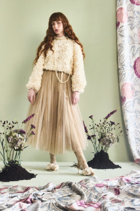 Woman in cream jumper and brown skirt | Luxury List December 2024