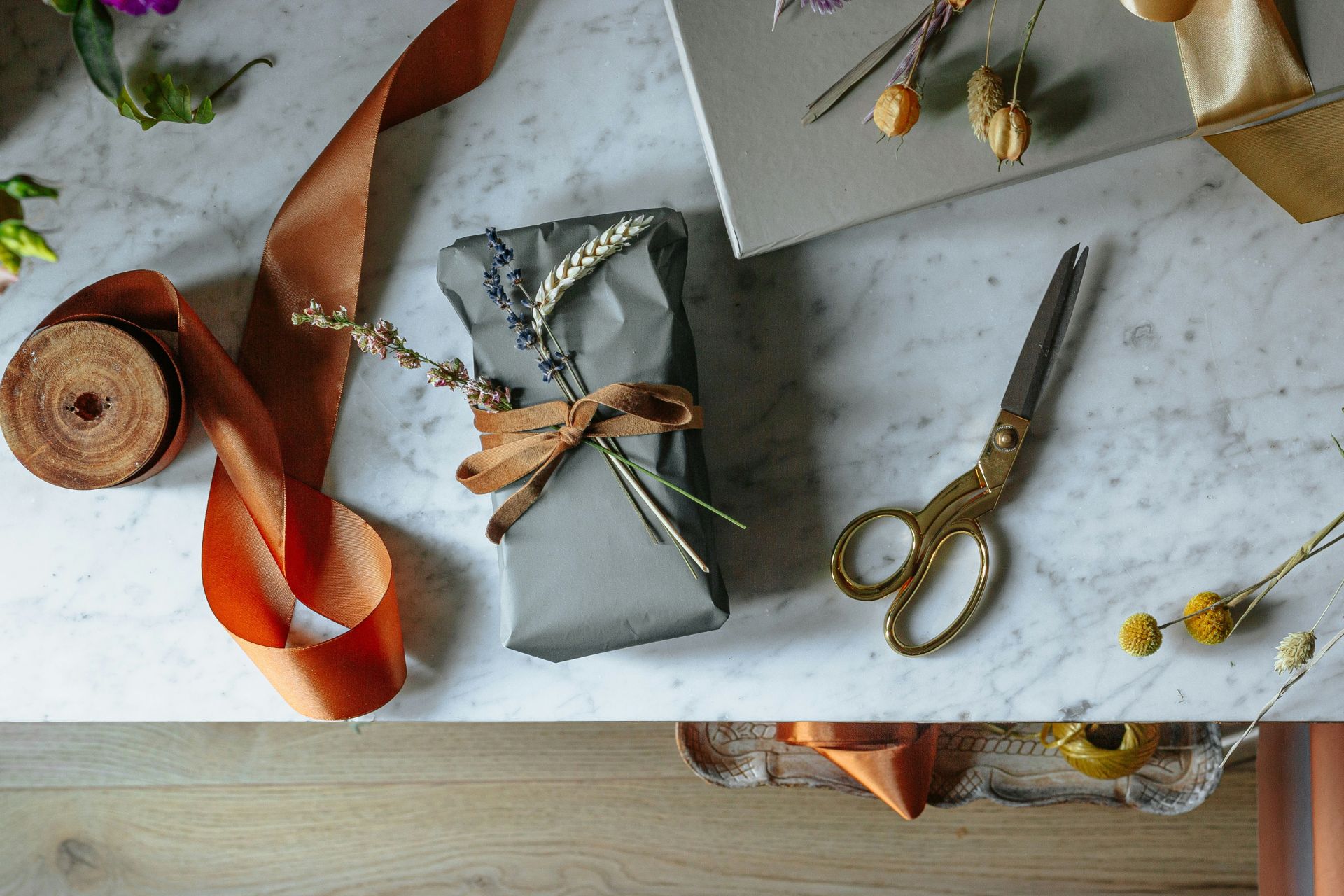 Wrapping paper, ribbon and a pair of scissors on a marble table