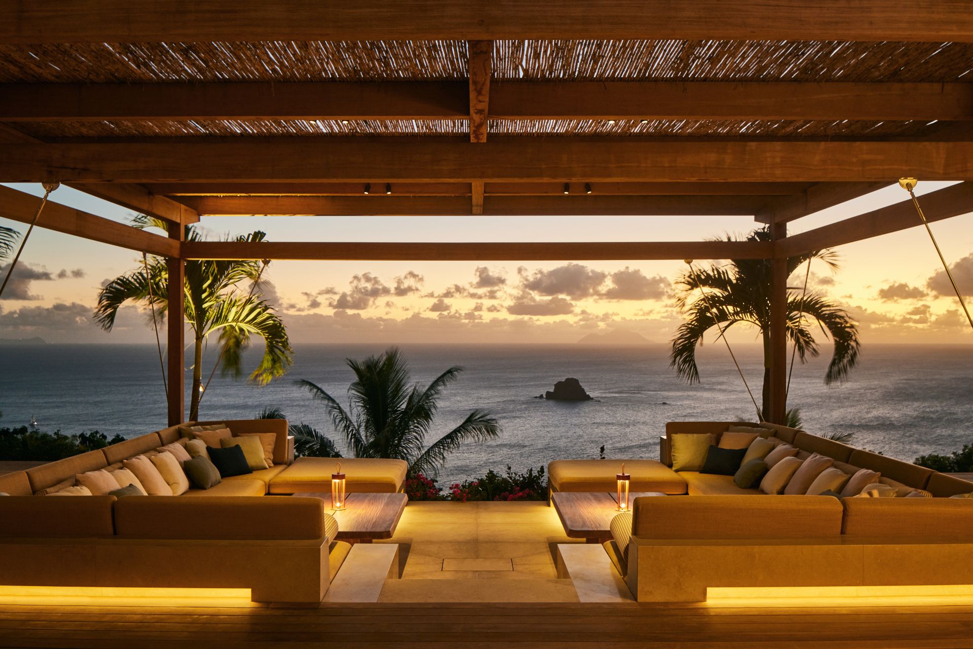 Beachfront terrace with yellow sofas at sunset