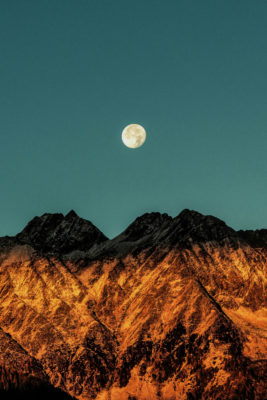 Full moon over snowy mountains