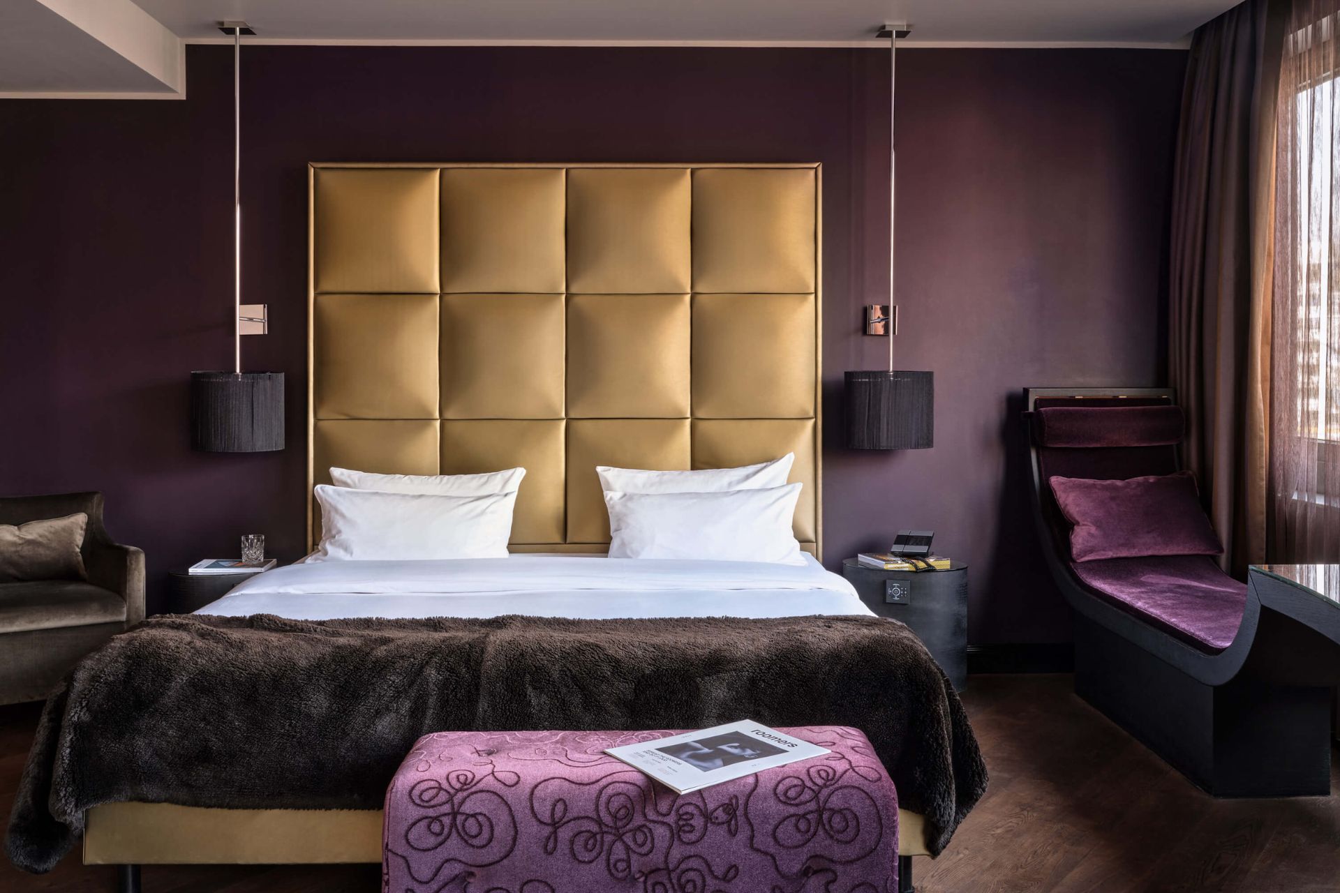Purple hotel room with gold cushioned headboard