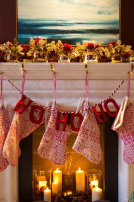 Mantelpiece with red garland, white and red stockings and candles