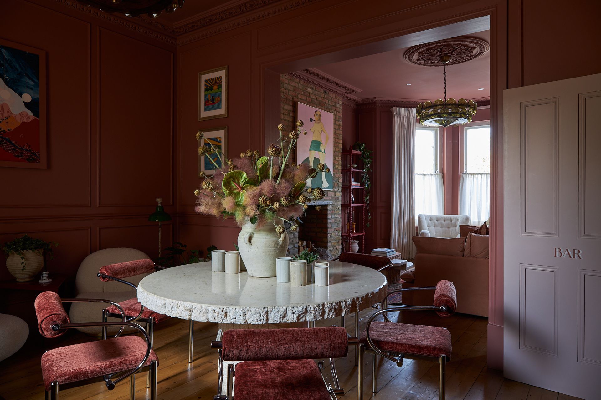 Dusty pink dining room with a white marble table and dark pink velvet chairs