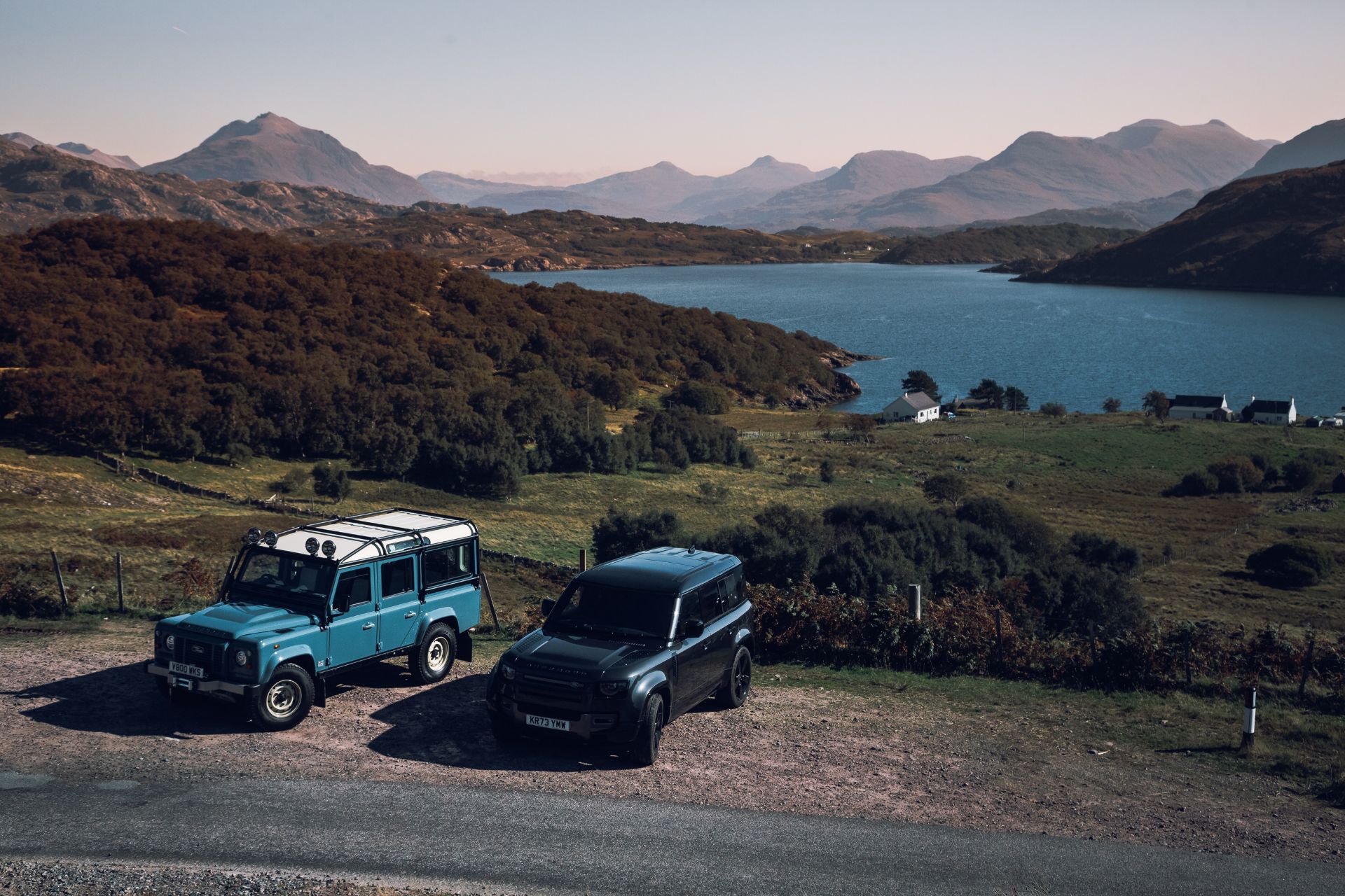 Two Land Rovers parked beside a loch