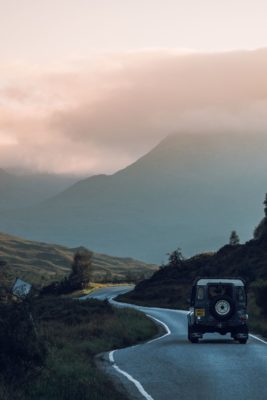 Land Rover on Highland road at sunset