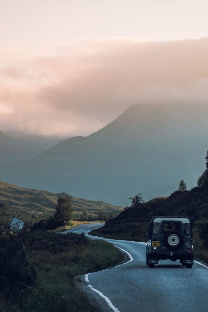 Land Rover on Highland road at sunset