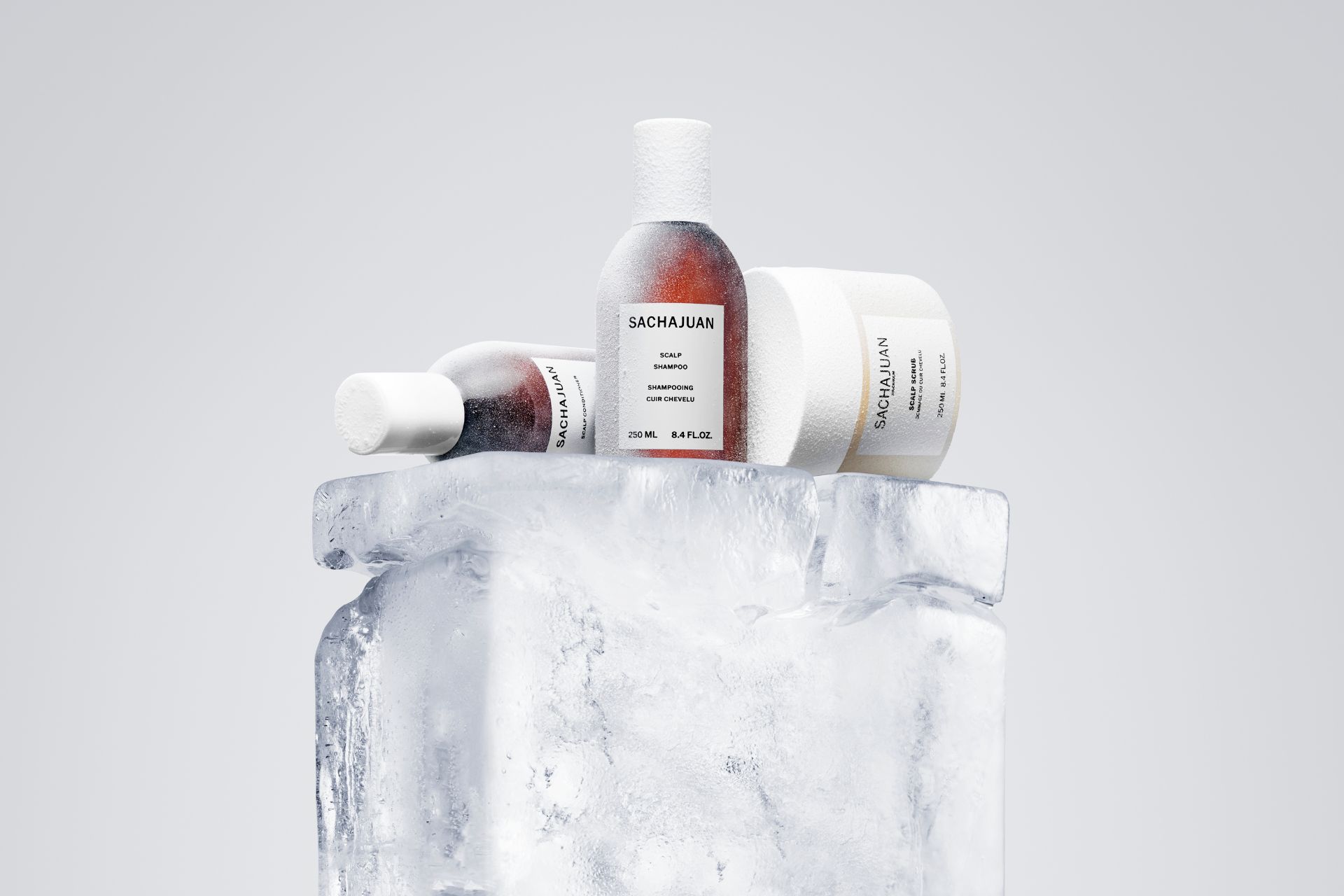 Bottles of Sachajuan hair products on a white marble plinth