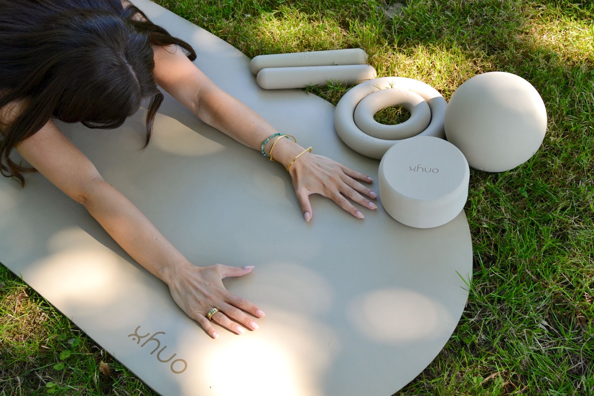 Model in child's pose on a grey yoga mat with matching equipment