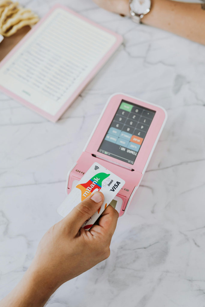A hand paying on a contactless card machine