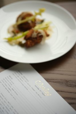Starling menu beside a plate of duck and vegetables