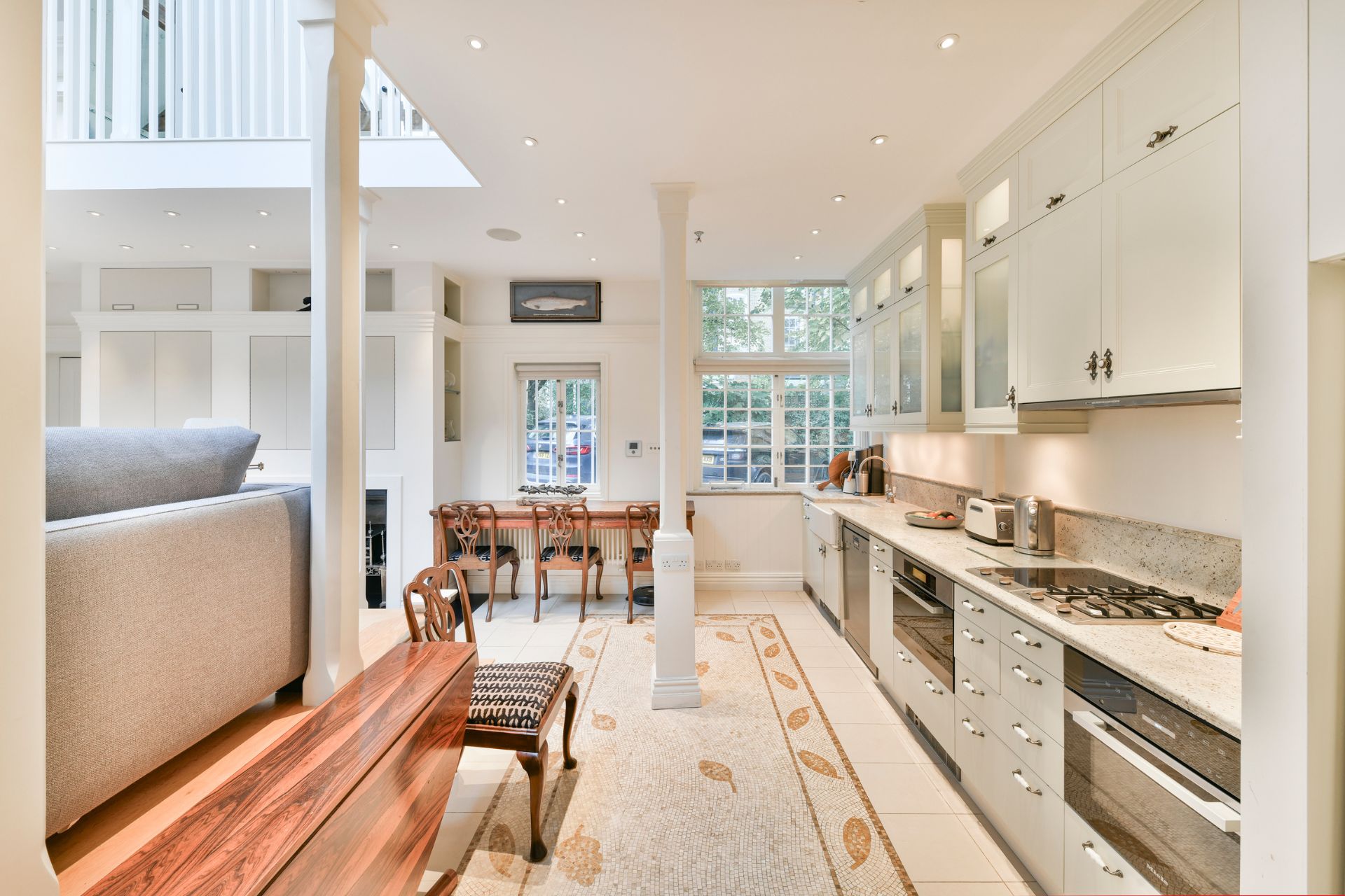 Kitchen with granite wortktops, sage green cabinets and wooden furniture