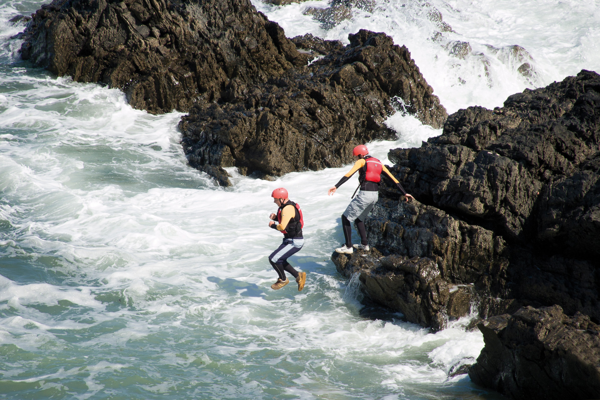 "Croyde, North Devon, England - June 15th 2009: A man jumping into the ocean. This is part of an extreme sport called Coasteering. Coasteering is a coastal route sport where you will climb, scramble, traverse, swim, go through caves & crevasses, get washed around in the swell, jump and freefall your way to an adrenaline pumping time!"