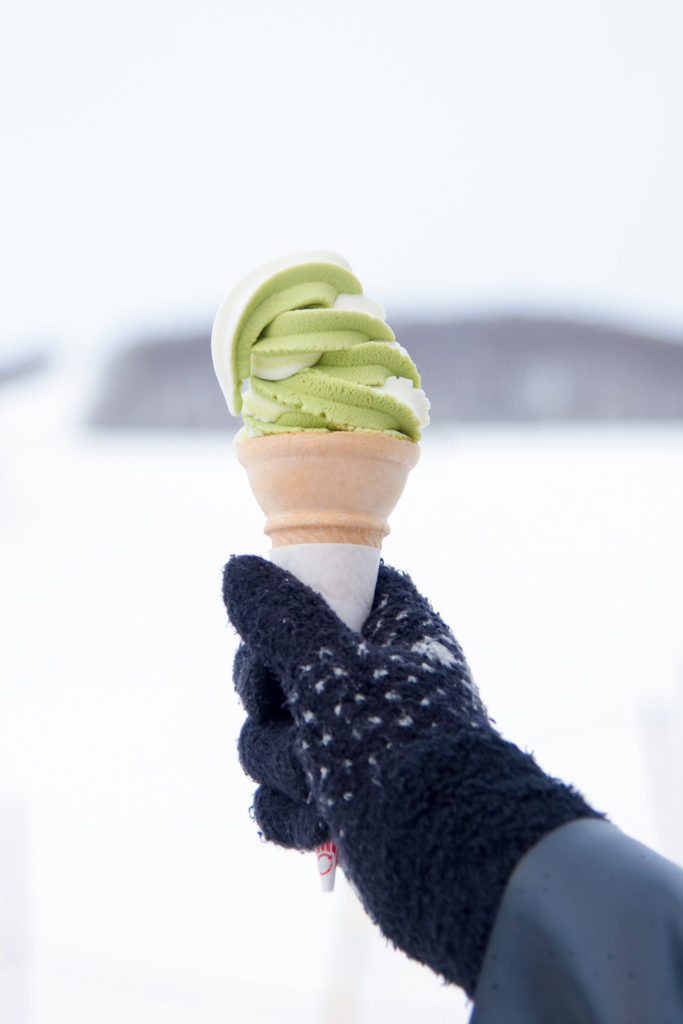 Hand holding an ice cream in the snow