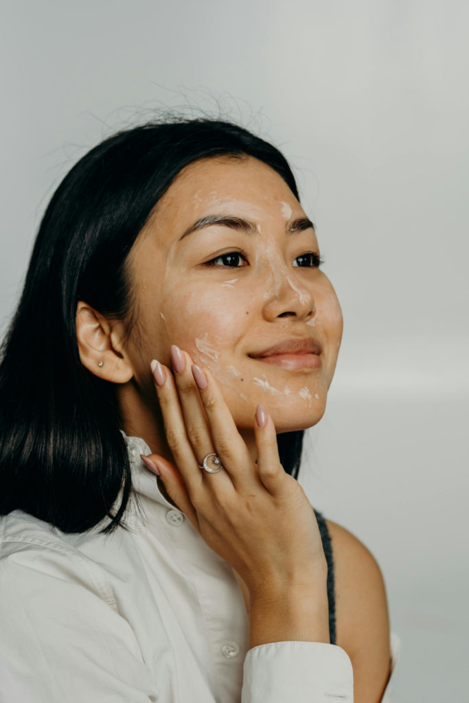 Woman putting cream on face