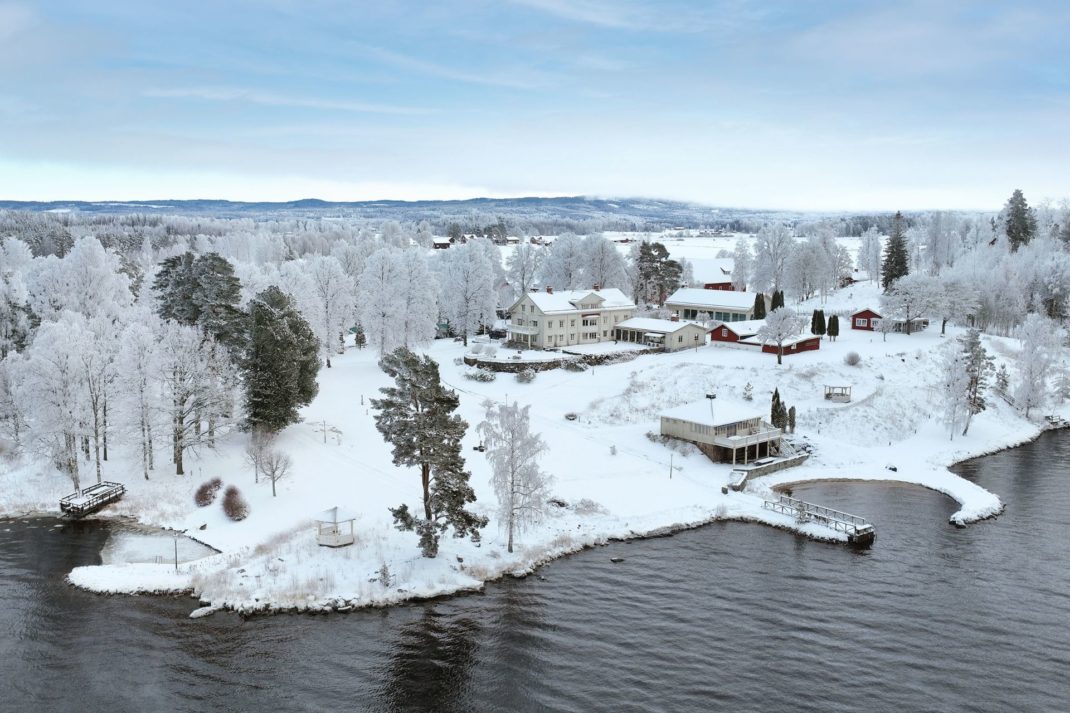 Aerial view of lakeside Stockhom estate with pool and lagoon-shaped beach