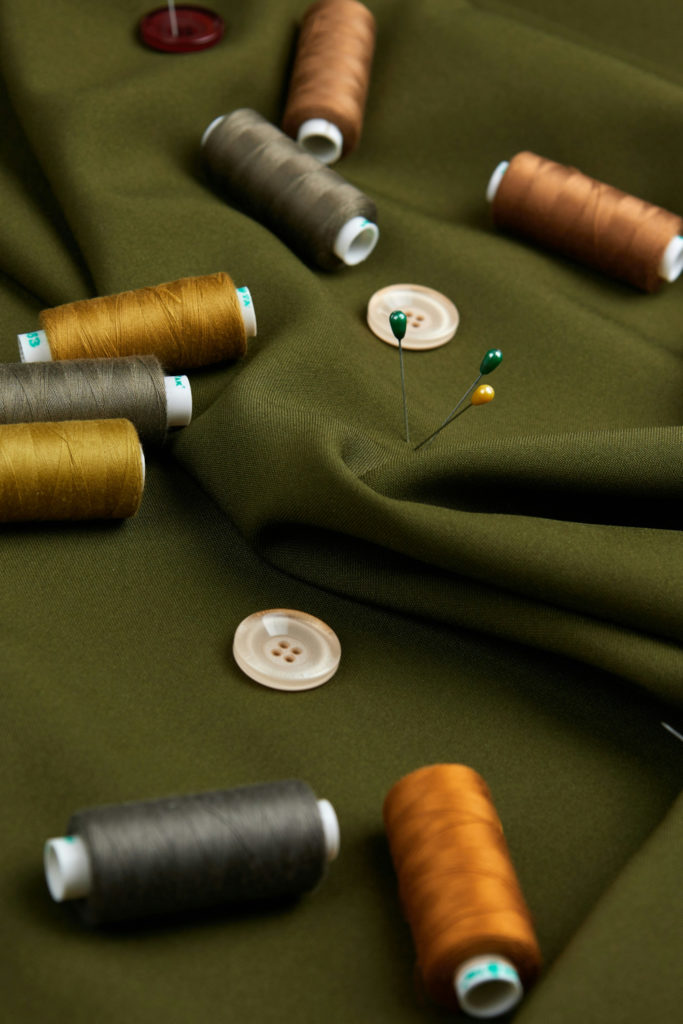 Green fabric with threads and pins