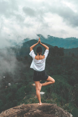 Woman stood on rocks | meditation apps