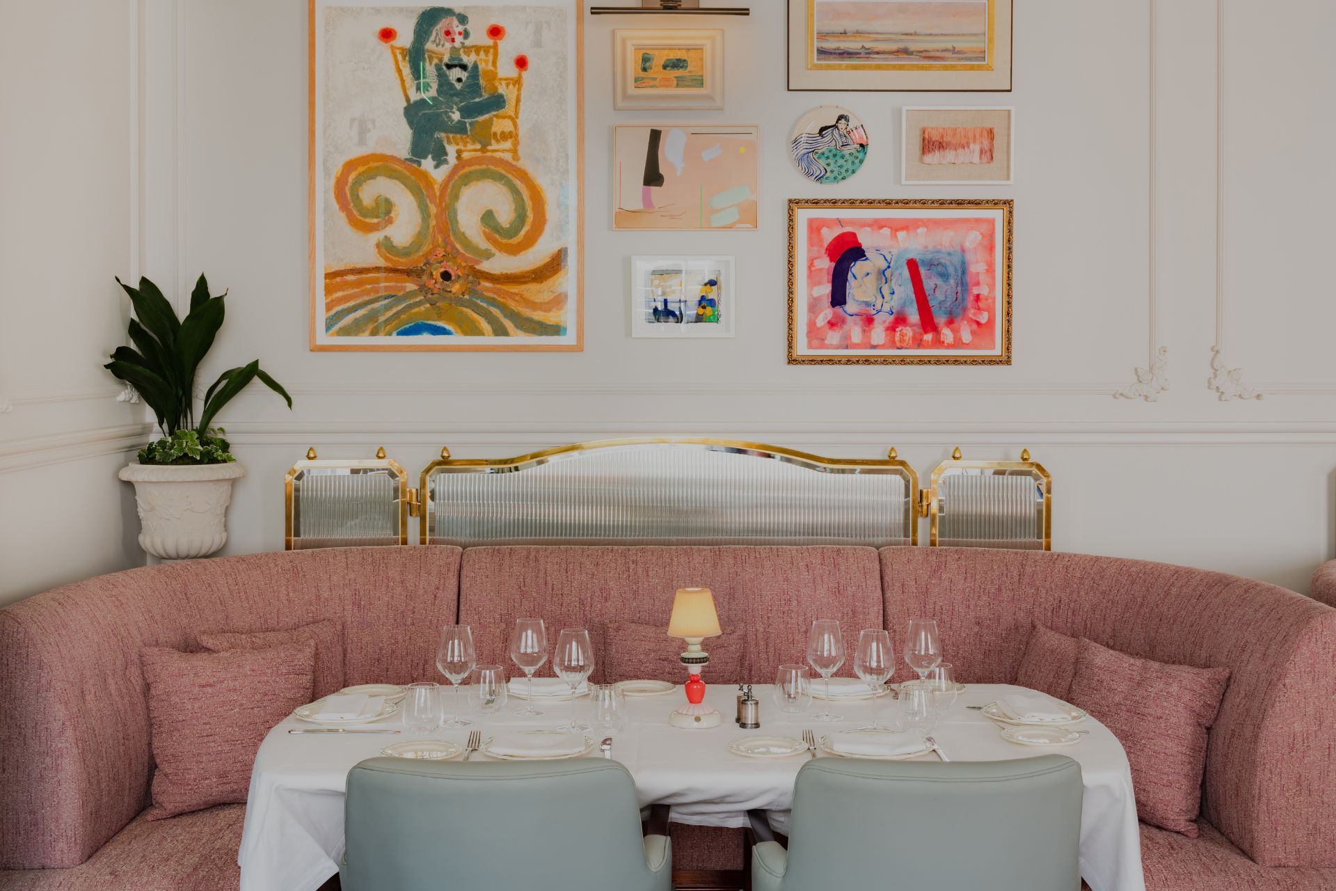 Restaurant with pale pink banquette and a gallery wall