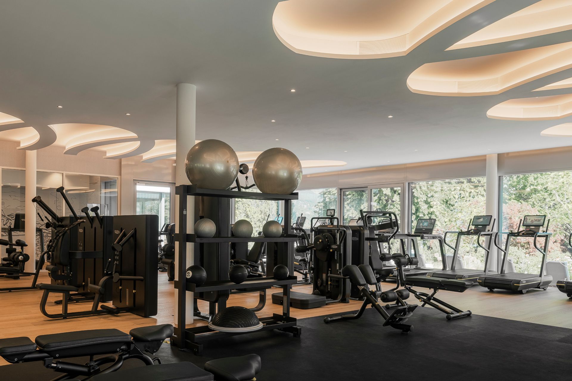 Hotel gym with black mats, running machines and racks