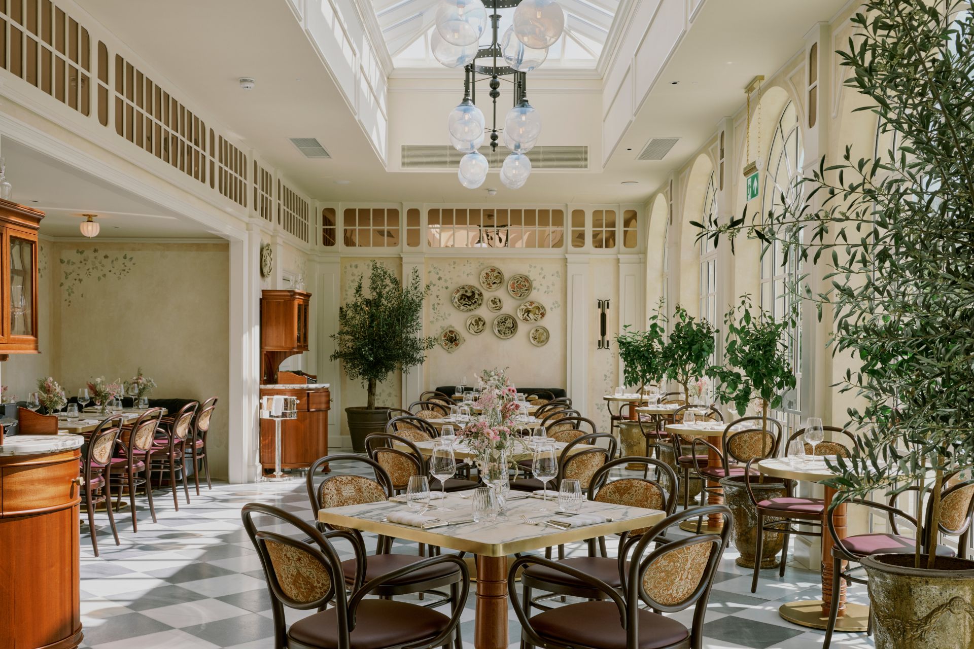 Estelle Manor orangery with wooden chairs, marble tables and gold accents