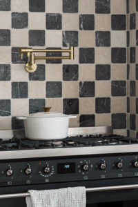 A pan on a hob with checkered tiles