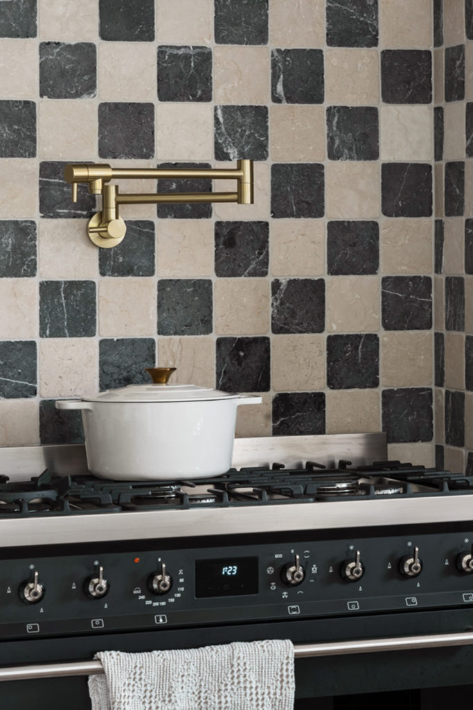A pan on a hob with checkered tiles