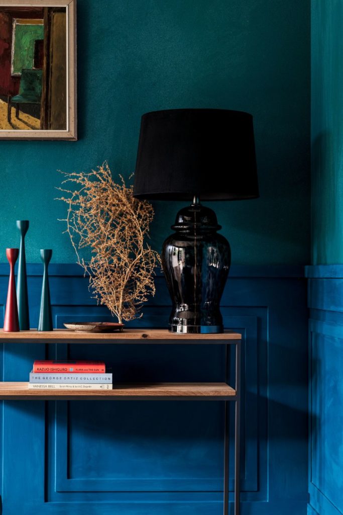 Hallway with teal walls and a wooden console table