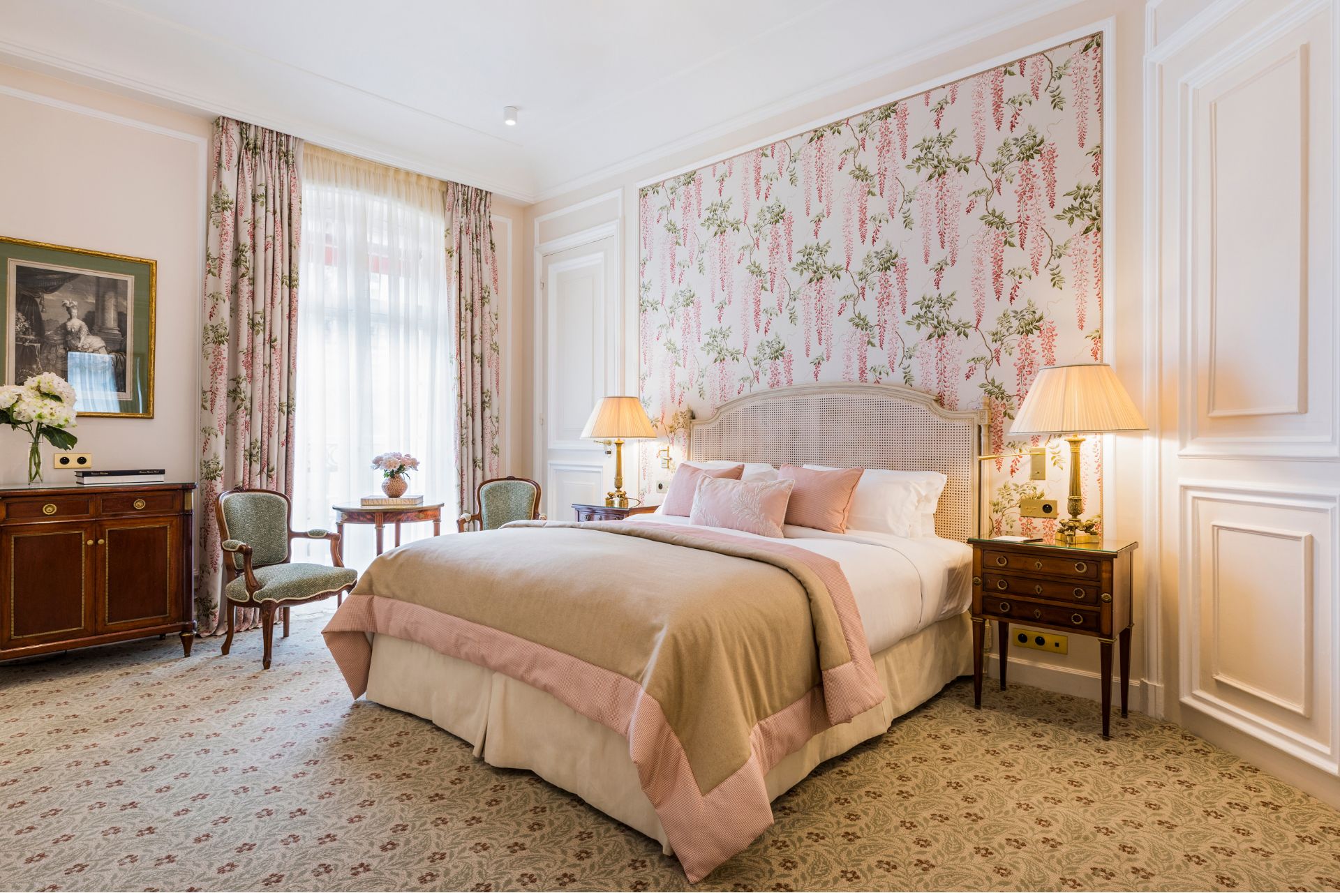 Hotel bedroom with floral wallpaper, pink accents and floral curtains