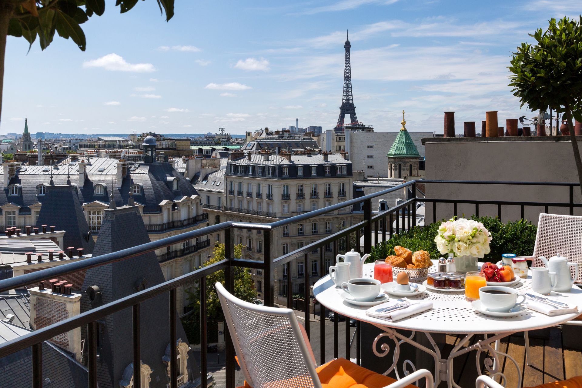 Hotel terrace with a marble dining table, overlooking the Eiffel Tower