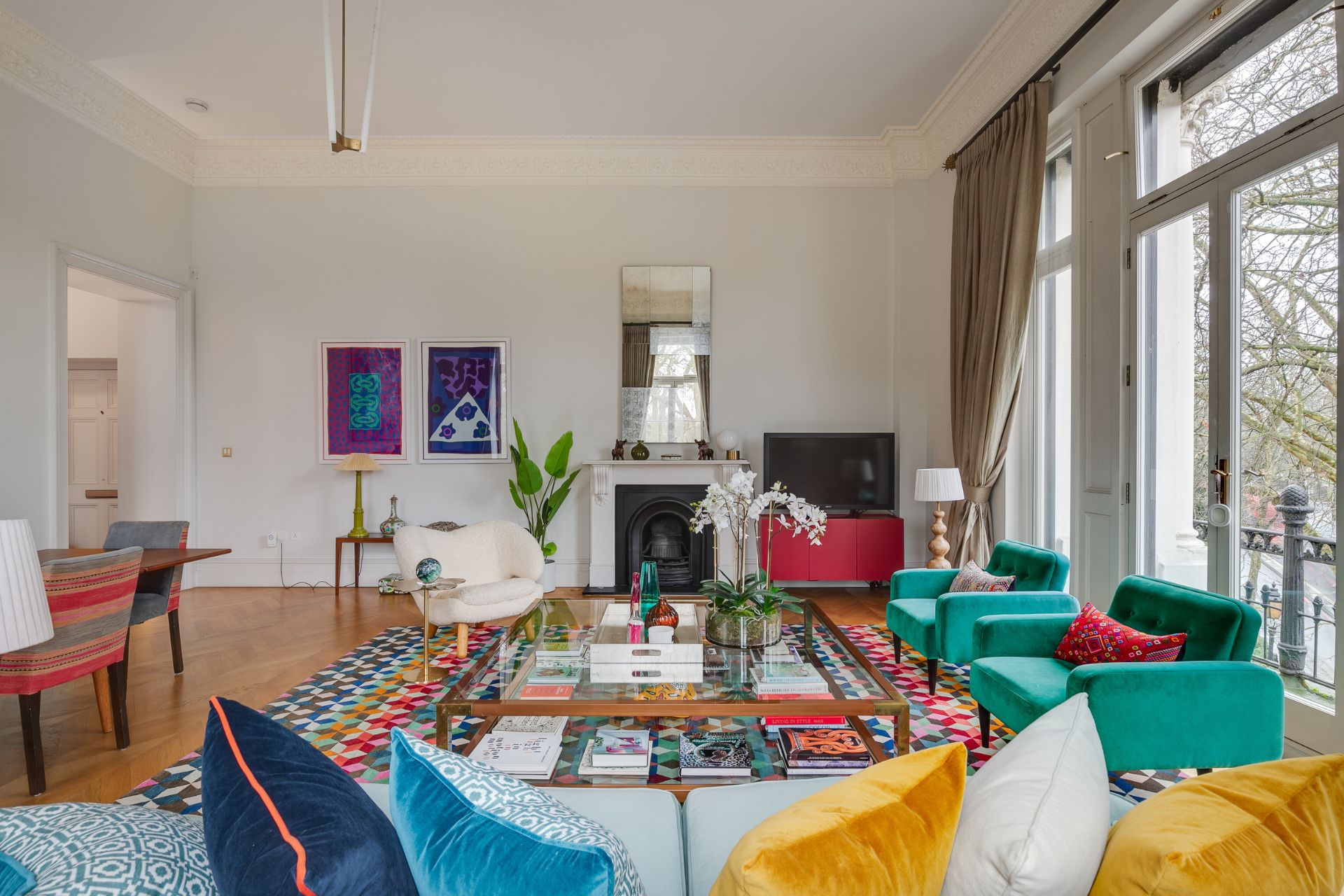 Living room with fireplace. dining area and teal armchairs