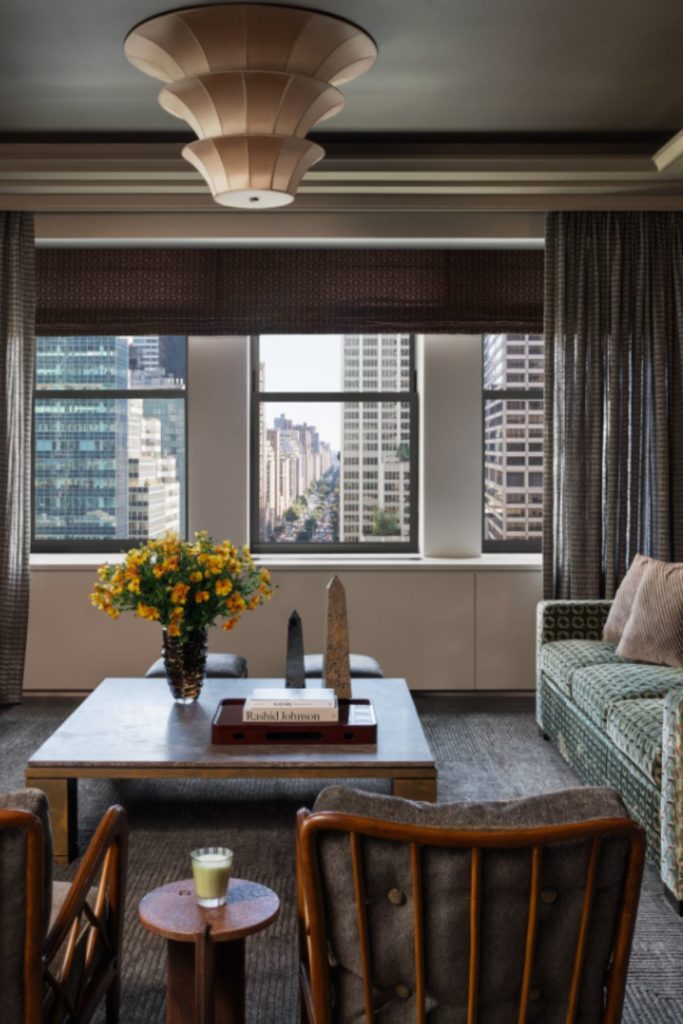 Living room with patterned green and white sofas and views of Manhattan