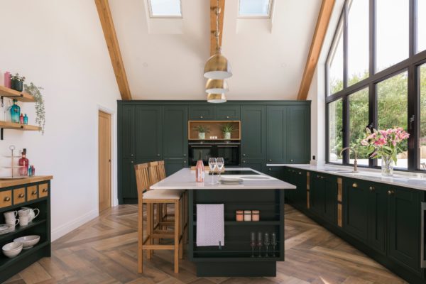 Kitchen with vaulted ceilings, black cabinets and white worktops