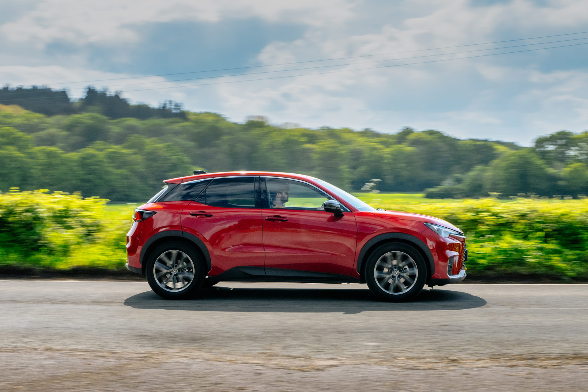 Red Lexus LBX on a country road